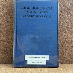 Puede incluir: Un libro azul con el título "Sidelights on Relativity" de Albert Einstein. El libro es una primera edición en inglés de 1922.