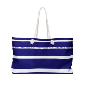 May include: A large tote bag with a blue and white striped pattern. The bag features white rope handles and the word "MAHJ" printed repeatedly in white along a horizontal band. The bag is designed for carrying items.