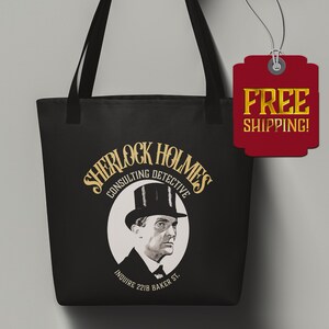 May include: Black tote bag with a gold design featuring Sherlock Holmes, a consulting detective. The design includes a portrait of Sherlock Holmes, the text "Sherlock Holmes Consulting Detective", and the address "221B Baker St."