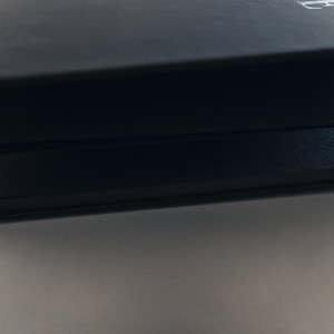 May include: Three black notebooks stacked on top of each other. The top notebook has a white letter "H" embossed on the cover.