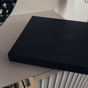 May include: A black box with the word "ONE" embossed on the top.