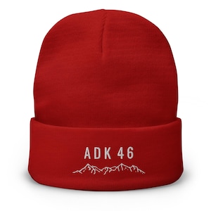May include: Red knit beanie with a white embroidered mountain range and the text "ADK 46".