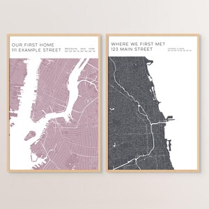 May include: Two framed vertical wall art prints featuring map designs. The left print is mauve with the text OUR FIRST HOME 111 EXAMPLE STREET BROOKLYN NEW YORK. The right print is dark gray with the text WHERE WE FIRST MET 123 MAIN STREET CHICAGO ILLINOIS.