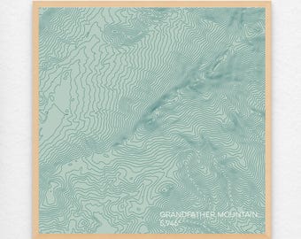 May include: A topographic map print of Grandfather Mountain, featuring detailed contour lines in shades of blue and green on a light green background. The text "Grandfather Mountain 5,946" is printed in the bottom right corner.