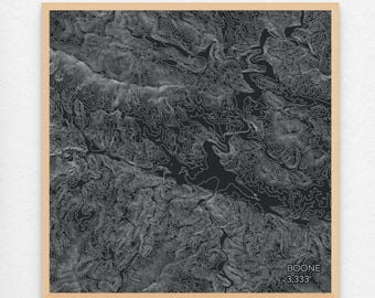 May include: A black and white topographic map print of Boone, North Carolina. The map shows the elevation contours of the area. The print is framed in a light wood frame.
