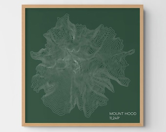May include: A square framed wall art piece featuring a dark green background with white topographic contour lines representing Mount Hood. The text MOUNT HOOD 11,249' is printed in white in the bottom right corner of the print.