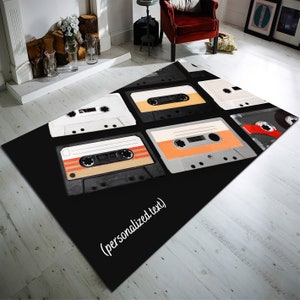 May include: Black and white cassette tapes on a black rug. The rug has the text "(personalized text)" in white.