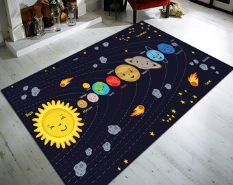 Puede incluir: Una alfombra azul y negra con un diseño de sistema solar de dibujos animados. El sol, los planetas y las estrellas están representados en colores brillantes. La alfombra presenta los nombres de cada planeta, incluyendo Mercurio, Venus, Tierra, Marte, Jupiter, Saturno, Urano y Neptuno.