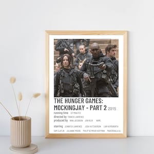 May include: A minimalist movie poster for "The Hunger Games: Mockingjay - Part 2" (2015). The poster features a black and white image of the main characters from the film, including Jennifer Lawrence, Josh Hutcherson, and Liam Hemsworth. The title of the film is written in bold, white text at the bottom of the poster.