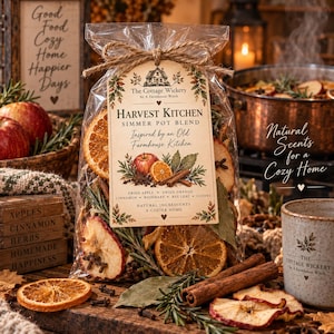Puede incluir: Una bolsa de plástico transparente que contiene una mezcla para olla a fuego lento Harvest Kitchen con rodajas de manzana seca, rodajas de naranja, ramas de canela, romero y clavos. La etiqueta incluye el texto The Cottage Wickery y los ingredientes.