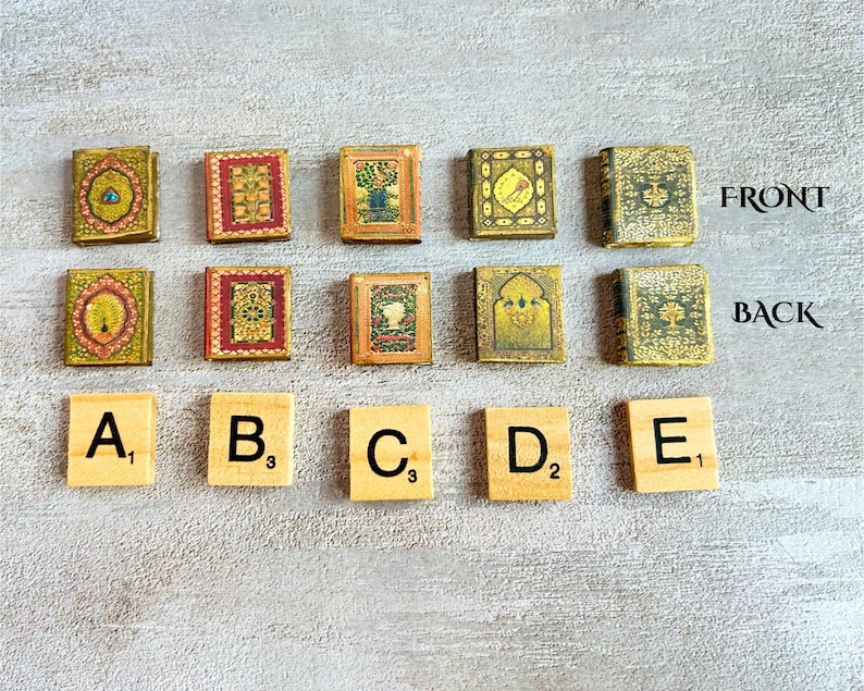 May include: A collection of miniature, decorative books with ornate, colorful covers. The books are arranged in two rows, with Scrabble tiles spelling out letters A through E below. The text "FRONT" and "BACK" are visible.