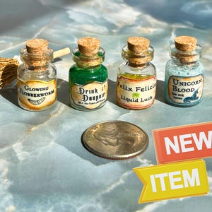 May include: Four miniature potion bottles with cork stoppers. The bottles are labeled "Glowing Flobberworm", "Drink of Despair", "Felix Felicis Liquid Luck", and "Unicorn Blood". A quarter and two "New Item" signs are also present.