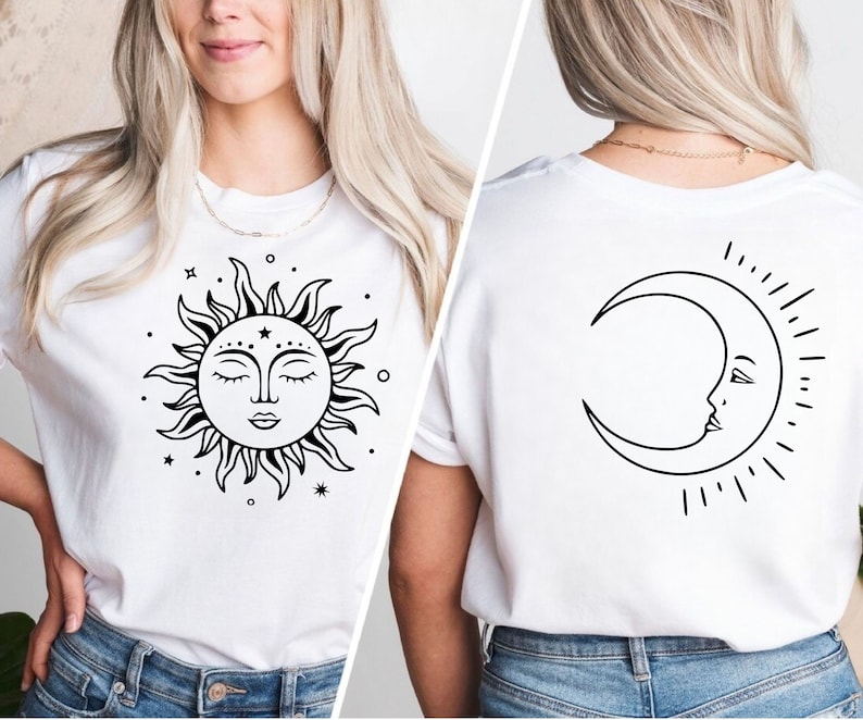 K&ouml;nnte beinhalten: Wei&szlig;es T-Shirt mit einem schwarzen Sonnen- und Monddesign. Die Sonne hat ein Gesicht mit geschlossenen Augen und der Mond hat ein Gesicht mit einem offenen Auge. Sonne und Mond sind von kleinen Sternen umgeben.