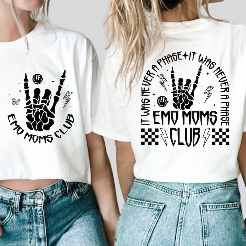 Puede incluir: Dos camisetas blancas con un dise&ntilde;o gr&aacute;fico negro de una mano de esqueleto haciendo un signo de rock and roll. El texto en las camisetas dice "Emo Moms Club" y "It was never a phase - It was never a phase - Emo Moms Club".