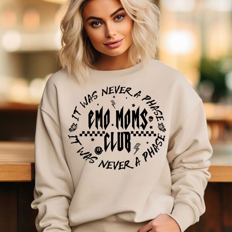 Puede incluir: Una sudadera beige con un estampado gr&aacute;fico negro que dice "It was never a phase Emo Moms Club It was never a phase".