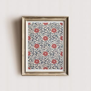 May include: A framed print featuring a floral pattern. The artwork showcases a repeating design of red flowers and dark blue leaves against a cream background. The frame is gold-colored, adding a touch of elegance to the botanical print.