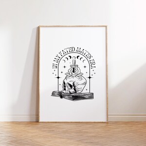 Puede incluir: Ilustraci&oacute;n en blanco y negro de una calavera con una daga atravesando una rosa, descansando sobre un libro. El texto "In My Fated Mates Era" rodea la imagen.