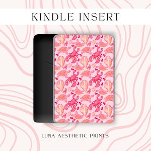May include: A Kindle Insert with a pink and red sea life pattern. The design features illustrations of lobsters, turtles, and seashells. The text "KINDLE INSERT" is at the top, and "LUNA AESTHETIC PRINTS" is at the bottom.