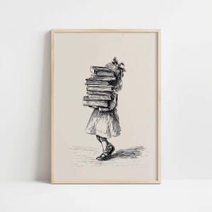 May include: A framed wall art print featuring a black ink line drawing on a cream background. The illustration depicts a figure with a bow in their hair carrying a tall, precarious stack of thick books, rendered in a detailed sketch style.
