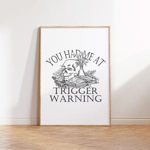 Puede incluir: Una ilustraci&oacute;n en blanco y negro de una calavera con flores en un jarr&oacute;n, con el texto "You had me at trigger warning".