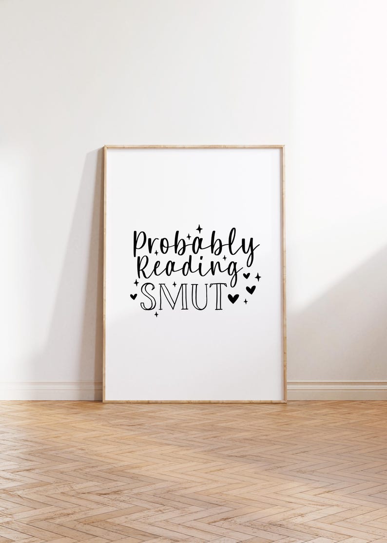 Puede incluir: Una impresi&oacute;n enmarcada con el texto "Probably Reading SMUT" en fuente cursiva negra con peque&ntilde;os corazones y estrellas alrededor del texto.