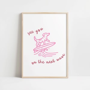 May include: Pink framed art print featuring a dog surfing on a wave. The illustration includes the text "see you on the next wave" in a handwritten style. The artwork is set against a white background.