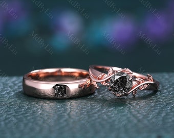Peut inclure: Une paire d'alliances en or rose avec une bague de fiançailles en diamant noir. La bague de fiançailles présente un délicat motif de vigne avec des feuilles.