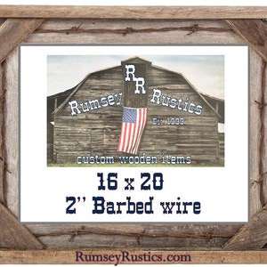 May include: A rustic wooden picture frame with barbed wire accents. The frame is 16 inches by 20 inches and has a 2 inch wide barbed wire border. The frame is made by Rumsey Rustics, a company that specializes in custom wooden items. The company's logo is a barn with the words "Rumsey Rustics" and "Est. 1999" on it.