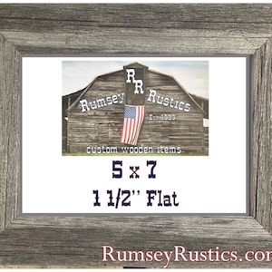 May include: A rustic wooden picture frame with a gray finish. The frame is 1 1/2 inches wide and is designed to fit a 5x7 inch photo. The frame is made by Rumsey Rustics, a company that specializes in custom wooden items.