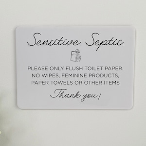 May include: A rectangular white sign with rounded corners. The sign has black text that reads "Sensitive Septic" and instructions on what can be flushed. A small illustration of a toilet paper roll is included. The sign ends with "Thank you!"