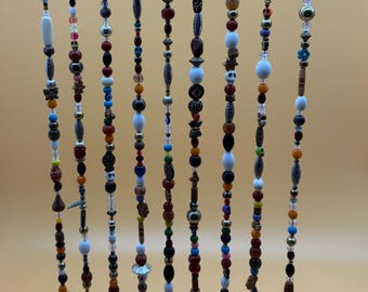 Campana protectora de bruja con cascabeles y cuentas variadas en percha de madera flotante