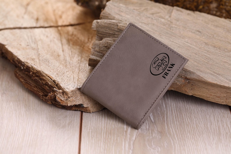 May include: A gray leather wallet with a logo and the name "FRANK" embossed on the front.