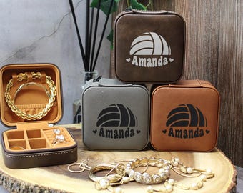May include: Four brown, gray, and tan faux leather jewelry boxes with a volleyball design and the name "Amanda" engraved on each. The boxes are stacked on top of each other.