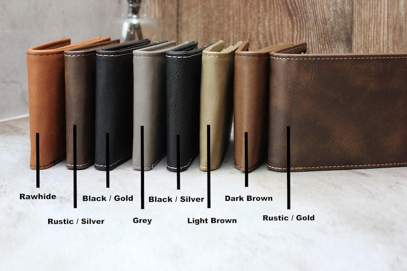 Puede incluir: Ocho carteras de cuero en diferentes colores y acabados, incluyendo cuero crudo, negro con costuras doradas, negro con costuras plateadas, marr&oacute;n oscuro, gris, marr&oacute;n claro y marr&oacute;n r&uacute;stico con costuras doradas. Las carteras est&aacute;n dispuestas en una fila de izquierda a derecha.