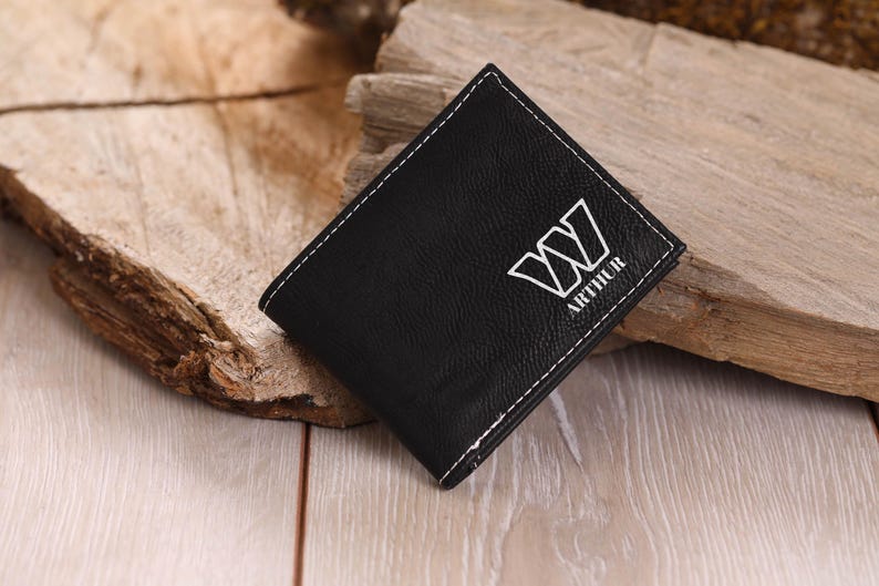 May include: Black leather wallet with white stitching and the name "Arthur" and a stylized "W" embossed on the front.