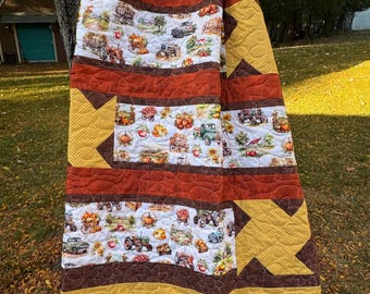 Farmin' Fall Harvest Quilted Throw,Patchwork quilt, Pickup trucks, tractors, barns, rust, gold, browns and creams. Measures 52 x 60 inches.