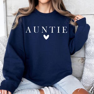May include: A navy blue sweatshirt with the word "AUNTIE" in white lettering and a white heart.