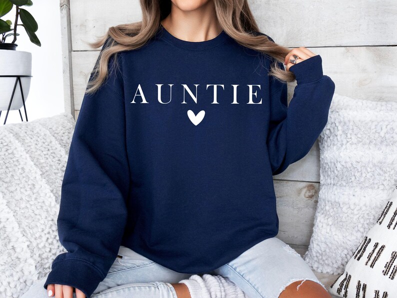 May include: A navy blue sweatshirt with the word "AUNTIE" in white lettering and a white heart.