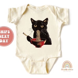 May include: A cream colored baby onesie with a black cat eating noodles from a red bowl. The cat is wearing a red collar and has a black nose and whiskers.
