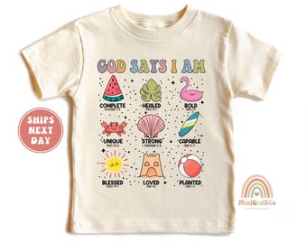 May include: A beige short-sleeved t-shirt with the text "God Says I Am" in colorful letters. The shirt features nine colorful illustrations of summer-themed objects, each with a word and a Bible verse underneath. The words are: Complete, Healed, Bold, Unique, Strong, Capable, Blessed, Loved, and Planted.