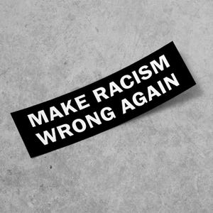 Puede incluir: Pegatina en blanco y negro con el texto "Make Racism Wrong Again" impreso en blanco sobre un fondo negro.