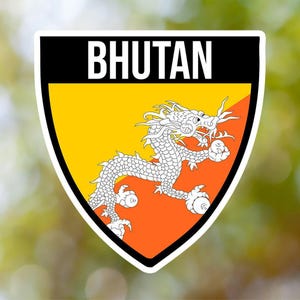 Może przedstawiać: Biała naklejka z czarną ramką i napisem "BHUTAN" białymi literami. Naklejka przedstawia flagę Bhutanu z żółtym polem, białym smokiem i pomarańczowym polem.