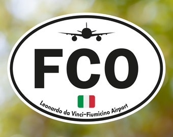 May include: White oval sticker with black text "FCO" and a silhouette of an airplane. Below the text is the Italian flag and the words "Leonardo da Vinci-Fiumicino Airport".
