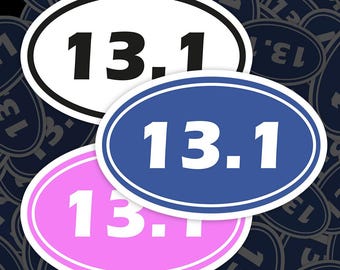 Puede incluir: Tres pegatinas ovaladas con el número 13.1 impreso en ellas. Las pegatinas son blancas con texto negro, azules con texto blanco y rosas con texto blanco.