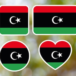 Op de afbeelding: Vier verschillende stickers met de vlag van Libië. De vlag is groen, zwart en rood met een witte halve maan en ster in het midden. De stickers zijn in de vorm van een vierkant, rechthoek, cirkel en hart.