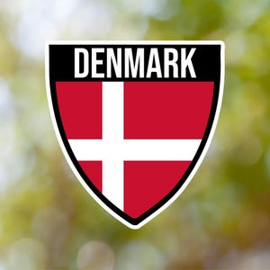 May include: A red and white shield with the Danish flag and the word "DENMARK" in black text at the top.