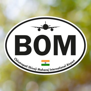 May include: Oval sticker with a black border featuring the letters "BOM" in bold black font, a silhouette of an airplane, and the text "Chhatrapati Shivaji Maharaj International Airport." An Indian flag is also present.
