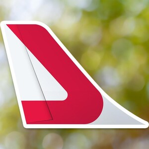 May include: A red and white airplane tail fin with a white triangle inside a red triangle.