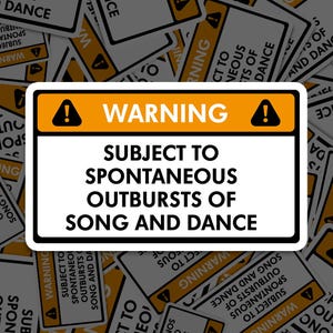 Puede incluir: Una pegatina blanca con borde negro y el texto "WARNING SUBJECT TO SPONTANEOUS OUTBURSTS OF SONG AND DANCE" en negro. La palabra "WARNING" es naranja con símbolos de signo de exclamación negros.