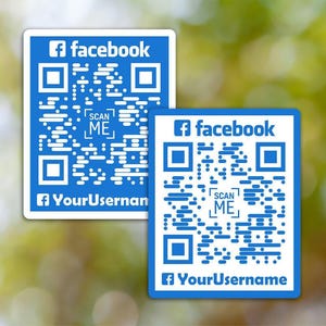Puede incluir: Dos pegatinas de código QR de Facebook azules y blancas. Cada pegatina tiene el logotipo de Facebook, las palabras "facebook", "SCAN ME" y un espacio para un nombre de usuario. El fondo es verde borroso.